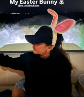 Woman wearing a black baseball cap with bunny ears.