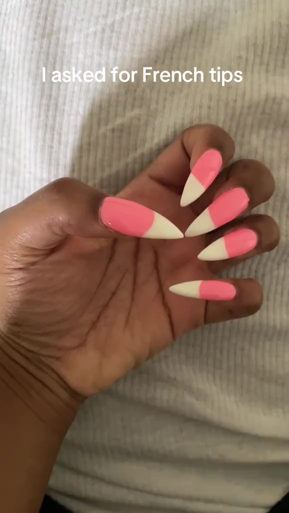 Hand with pink and white French tip nails.