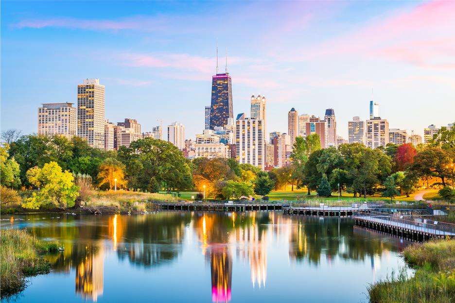 Chicago skyline reflected in a calm body of water.