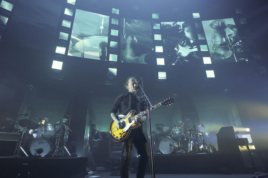 Radiohead performing live on stage.