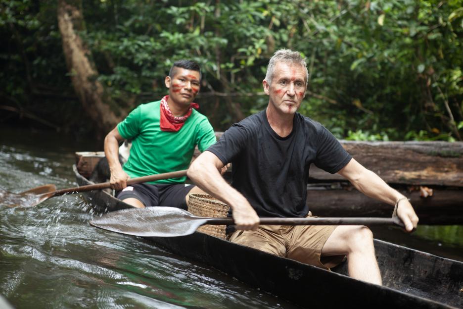 Two men canoeing on a river.