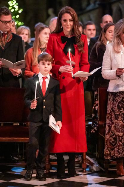 Prince Louis and the Princess of Wales holding lit candles at a Christmas carol service.