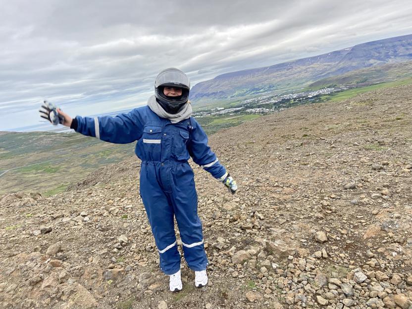 Person in motorcycle gear overlooking Icelandic landscape.