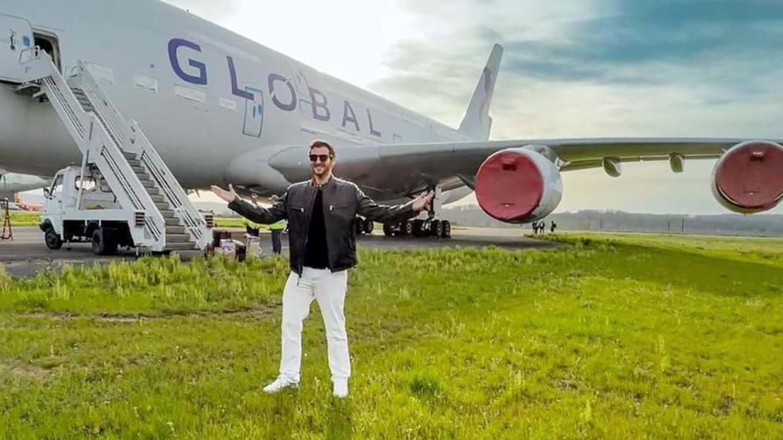 Man standing in front of a Global Airlines airplane.