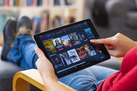 ¿stanbul, Turkey - July 1 2018: Woman using tablet computer and looking an online streaming platform. The tablet pc is an iPad Air 2, developed by Apple Inc.