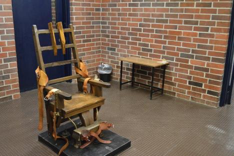 Electric chair in a brick room.