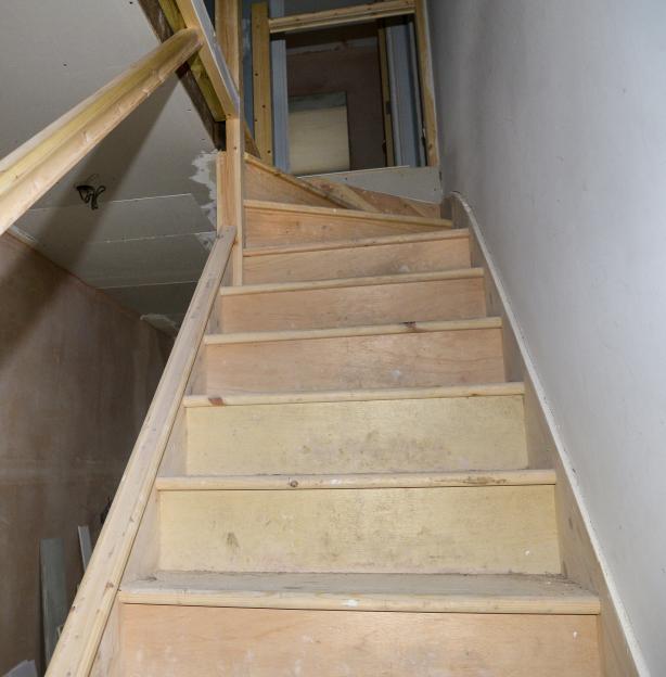 Unfinished wooden staircase in a house under construction.