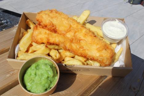 Fish and chips with mushy peas and tartar sauce.