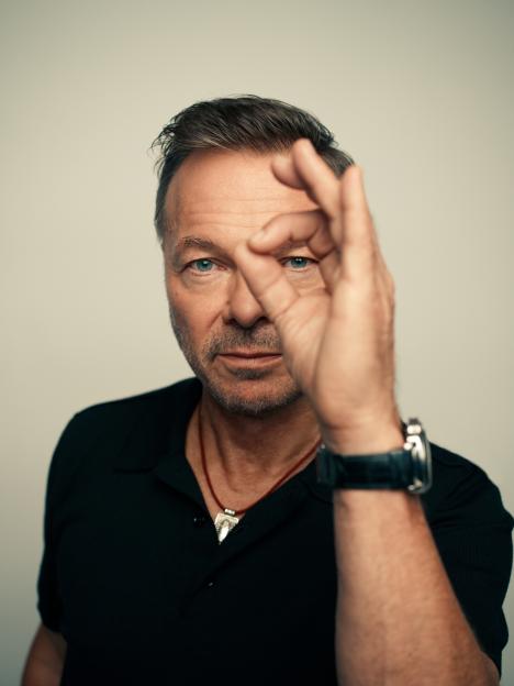 Portrait of Pete Tong making an "OK" hand gesture.