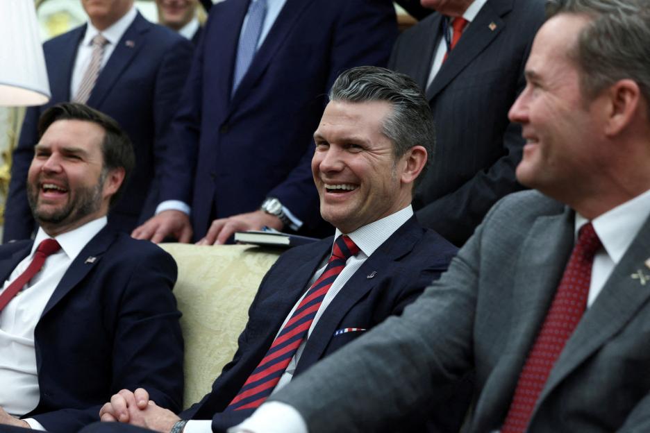 Three men in suits laughing together.