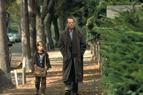 Still from The Sixth Sense showing Bruce Willis and Haley Joel Osment walking down a sidewalk.
