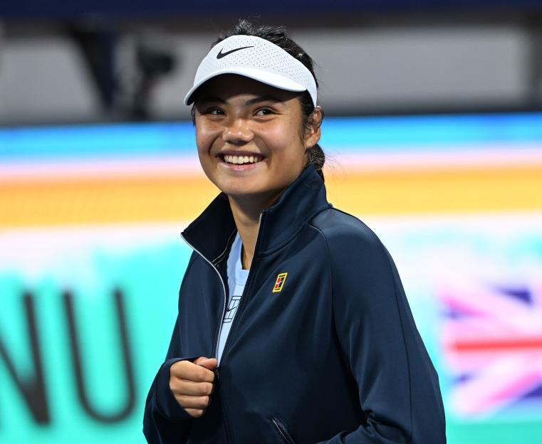 Emma Raducanu smiling at a tennis match.