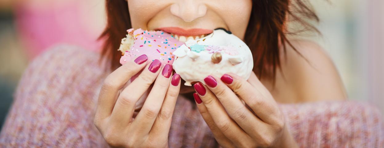 Woman eating two donuts.