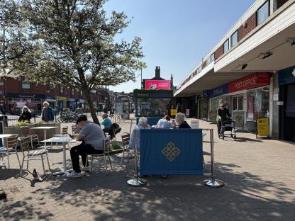 People sitting at outdoor cafe tables in Harborne, Birmingham.