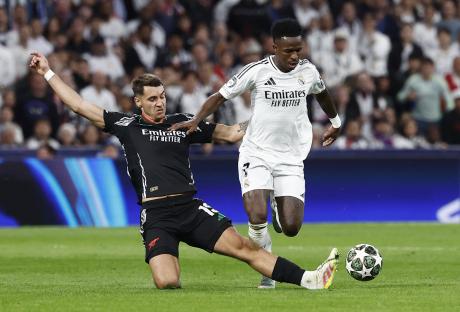 Vinicius Jr. of Real Madrid and Jakub Kiwior of Arsenal vying for the ball.