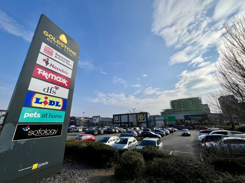 Goldstone Retail Park sign and parking lot with various stores.