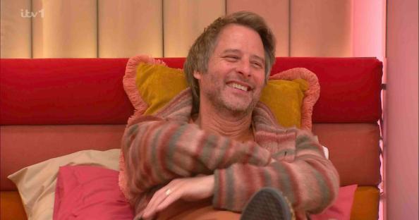 Chesney Hawkes smiling on a bed.