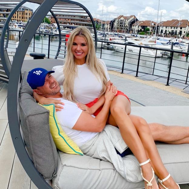 Christine McGuinness and Paddy McGuinness cuddling on a patio lounger.