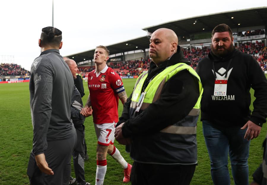 James McClean of Wrexham escorted off the pitch by security.