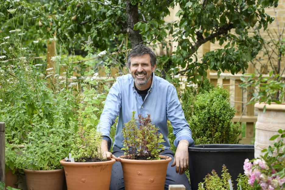 A man smiling while gardening.