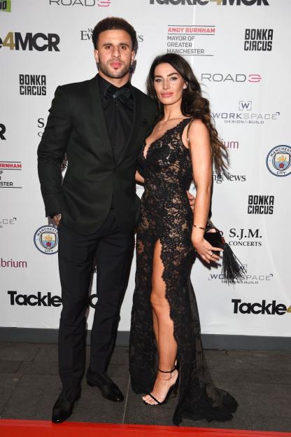 a man and a woman pose on a red carpet that says tackle