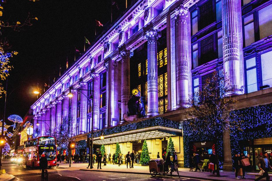 Selfridges department store in London at Christmas, illuminated with purple lights.