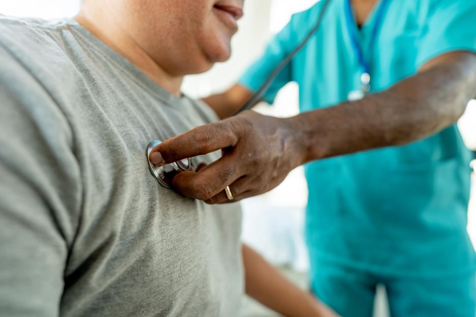 Doctor using a stethoscope to check a patient's blood pressure.