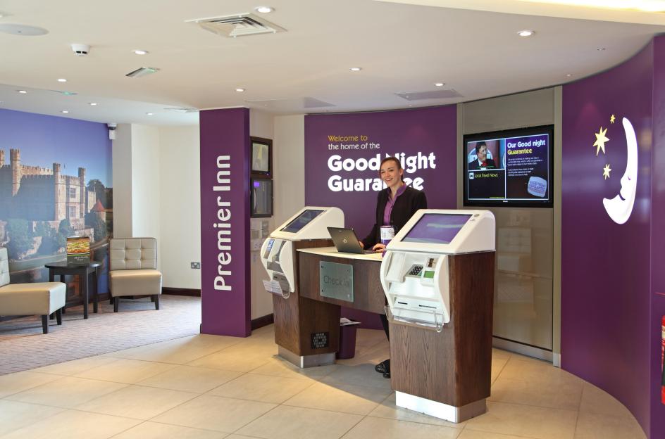 Premier Inn hotel reception desk with attendant.