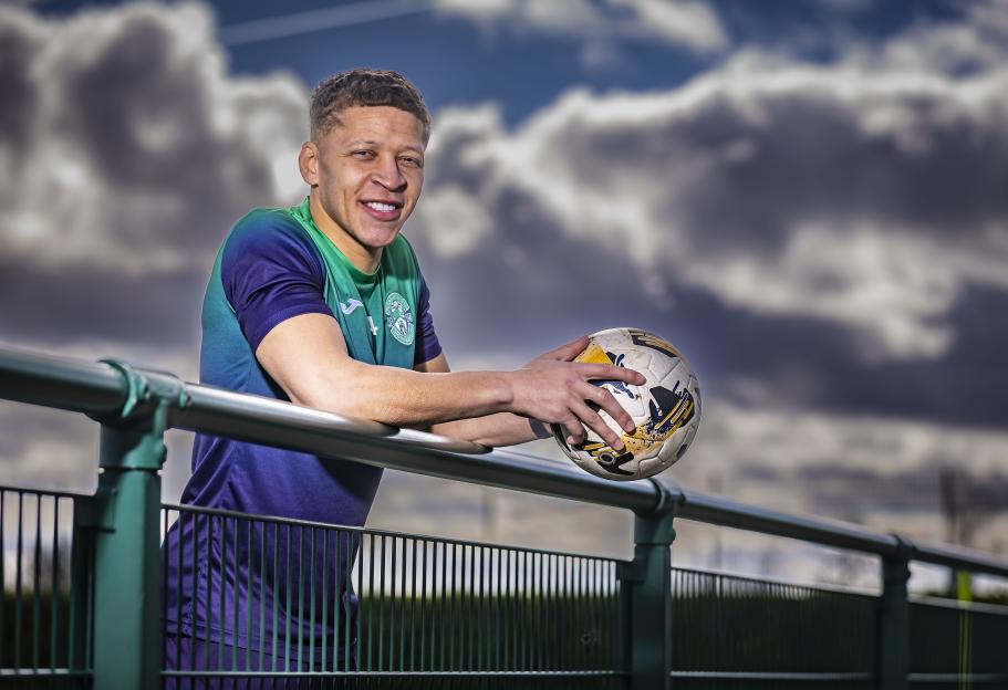 Dwight Gayle of Hibernian F.C. holding a soccer ball.