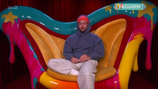 Chris Hughes crying on a colorful chair.