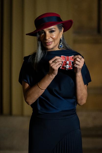 Dr. Shobna Gulati, actor, writer, and dancer, at an investiture ceremony, holding her Member of the Order of the British Empire medal.