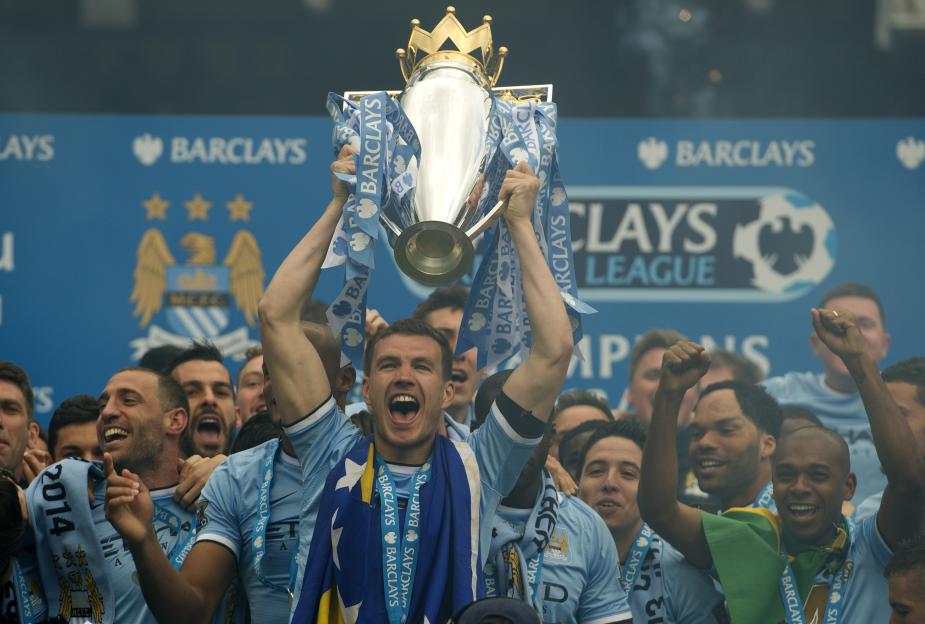 Edin Dzeko of Manchester City lifts the Barclays Premier League trophy.