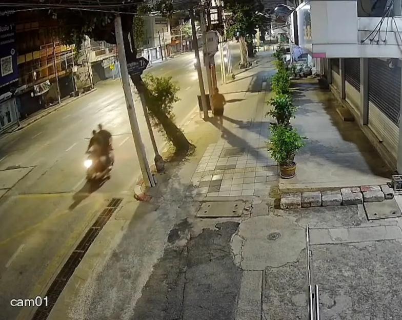 CCTV footage of a man on a motorcycle on a street at night.