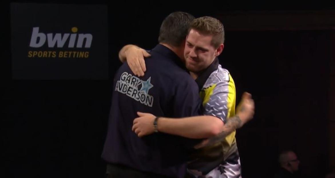 Two men embracing after a darts match.