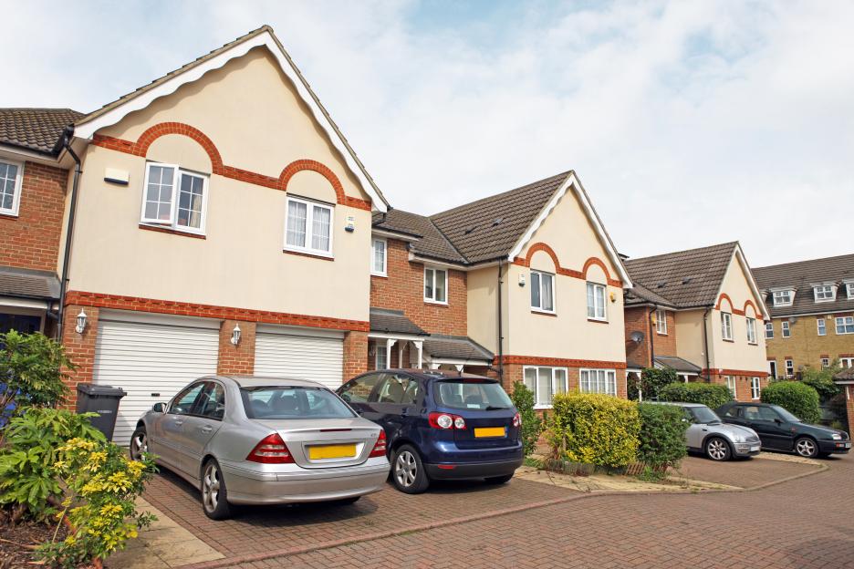 Newly built homes with cars parked in driveways.