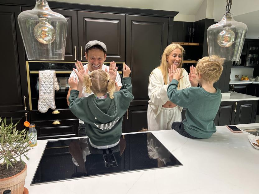 Family in kitchen giving high fives.