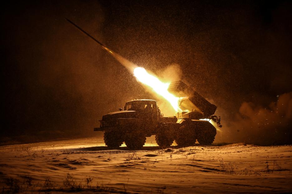 Ukrainian servicemen firing a BM-21 Grad multiple-launch rocket system at night.