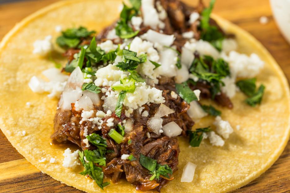 Homemade Mexican shredded beef taco with onions and cheese.