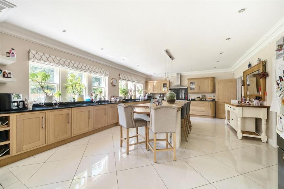 Large kitchen with light wood cabinets and a large island.