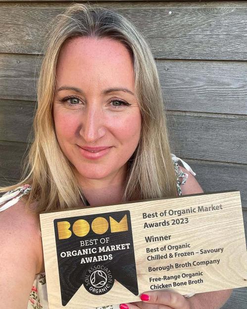 Woman holding award for Best of Organic Market Awards 2023.