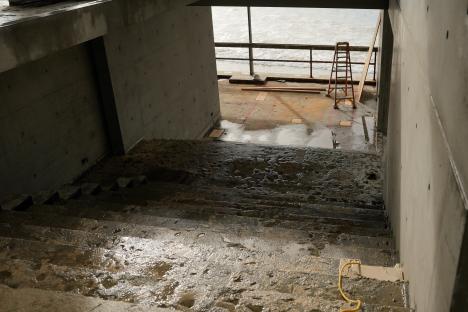 Wet concrete stairs leading to an ocean view during construction.