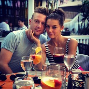 Couple sitting at a table with drinks.