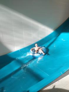 Boy going down a water slide in an inner tube.