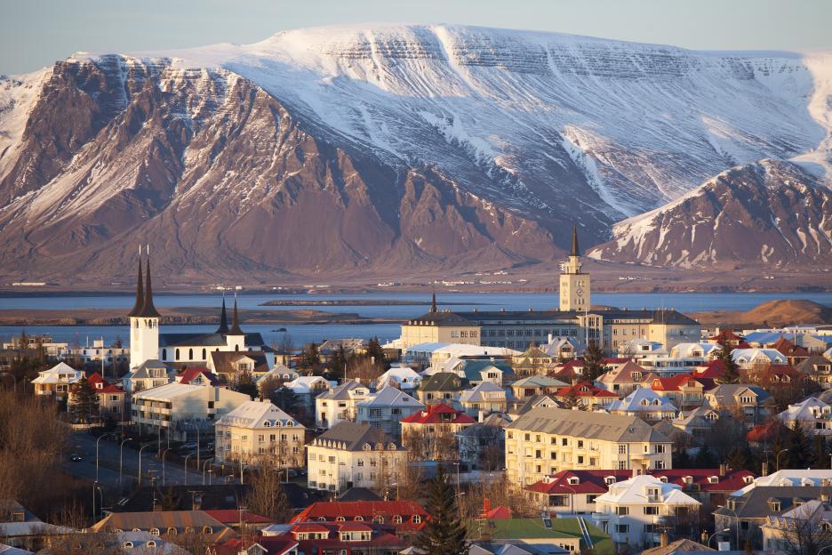 Cityscape with snow-capped mountains in the background.