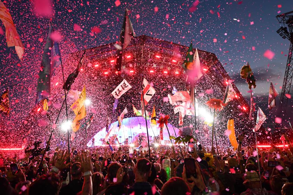 Crowd at a music festival with confetti falling.