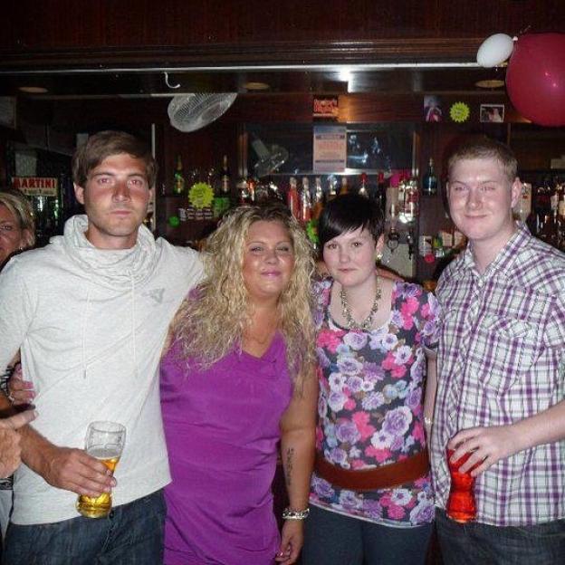 Group photo of four people at a bar.