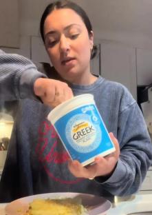 Person adding plain Greek yogurt to mashed potatoes.
