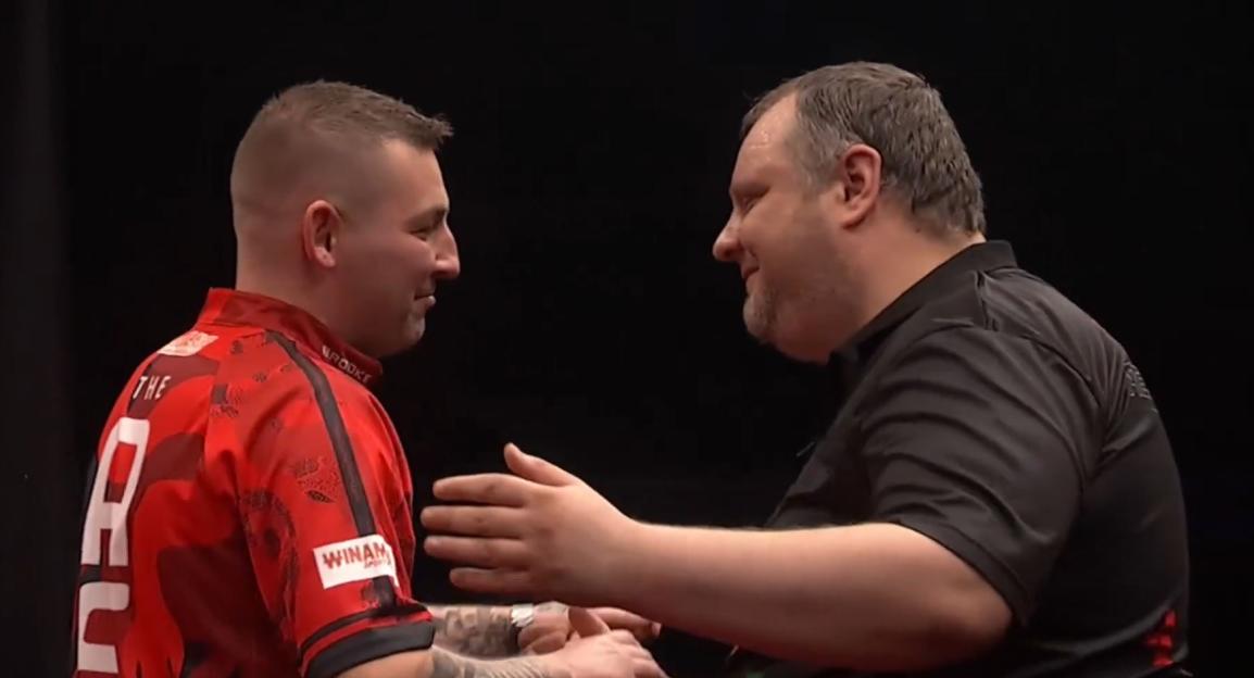 Two darts players shaking hands.