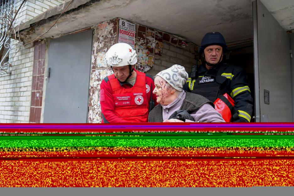 Ukrainian rescuers assisting an injured woman after a missile attack.