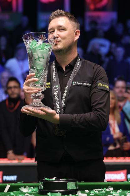 Kyren Wilson of England kisses the Players Championship trophy.